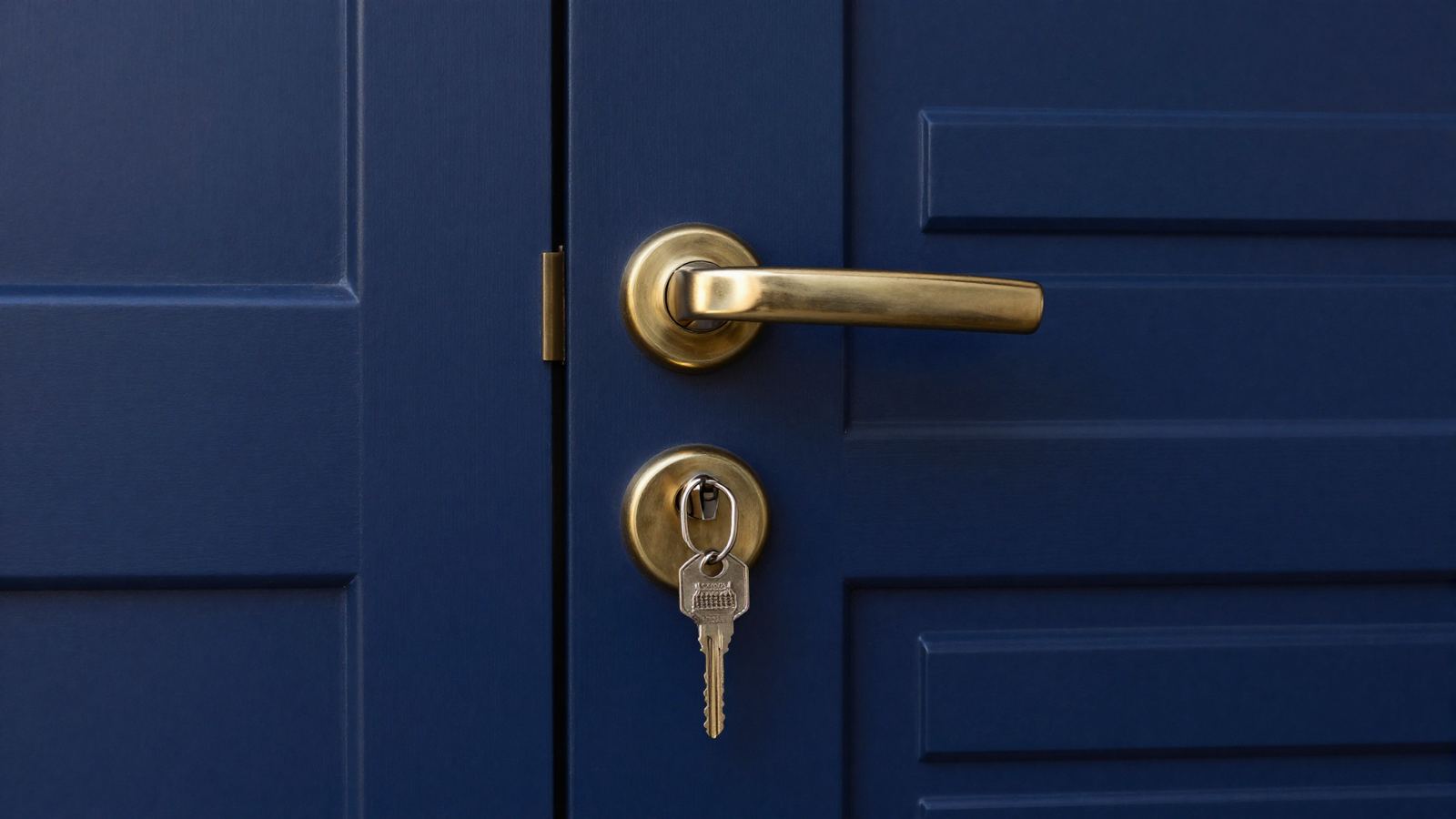 Modern front door with a secure brass lock and keys, photographed at dusk
